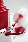 Roter Nagellack, geöffnetes Fläschchen mit Pinsel