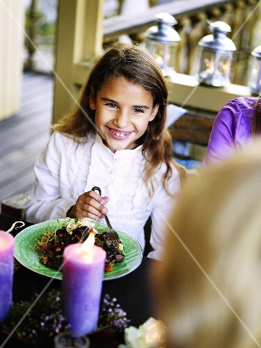 Little girl eating on a terrace