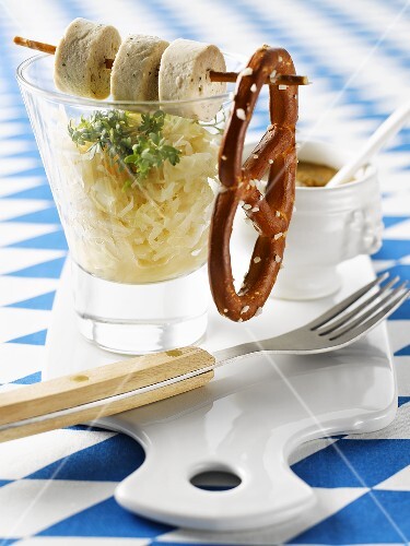 Sauerkraut in glass with slices of white sausage and salted pretzel