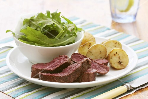 Fried ostrich fillet with a rocket salad and rosemary potatoes