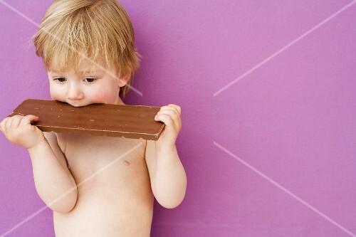 Junge beisst in Schokoladentafel