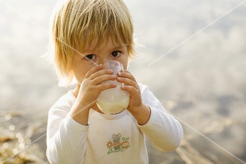 Kleiner Junge trinkt ein Glas Milch
