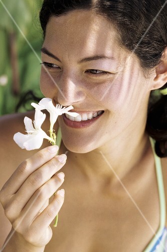Young woman sniffing a flower