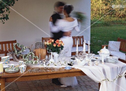 Wedding table with gifts, bride and groom dancing