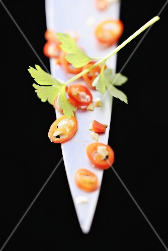 Chilli rings and parsley on the point of a knife