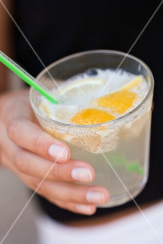 Hand holding a glass of lemonade