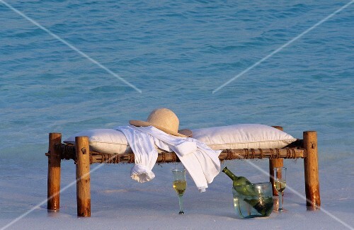Comfortable wooden bench & cooled white wine on sandy shore