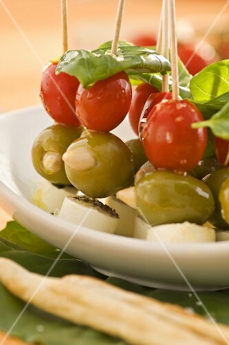 Tomatoes, olives and soft cheese on cocktail sticks