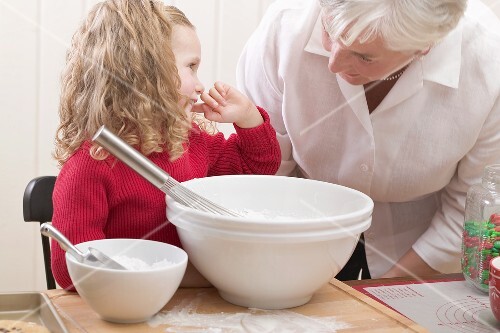 Grandmother and granddaughter baking Christmas biscuits