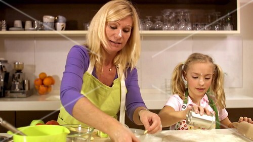 Mother and daughter baking apple tart together