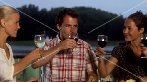 Four friends having evening meal together out of doors
