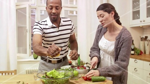 Couple preparing salad together