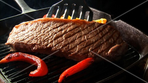 Strips of red pepper and steak in a grill frying pan