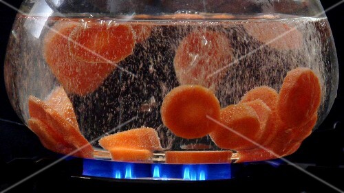 Carrot slices being cooked in hot water