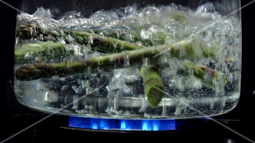 Asparagus tips falling into boiling water