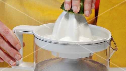 Squeezing a lime with an electric citrus squeezer