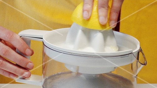 Squeezing a lemon with an electric citrus squeezer