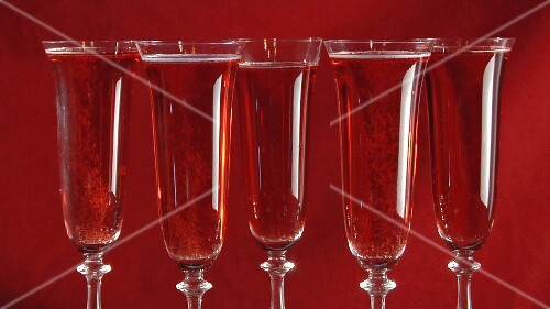 Sparkling rosé wine in five glasses