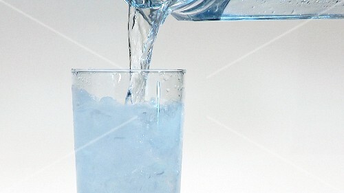 Pouring water into a glass of crushed ice