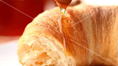 Croissant with honey (close-up)