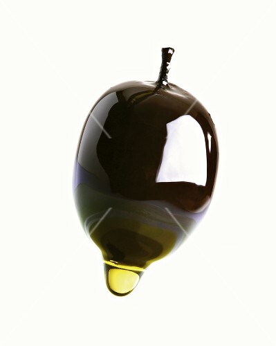 Olive oil dripping from an olive
