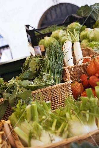 Vegetables and herbs in baskets at a market