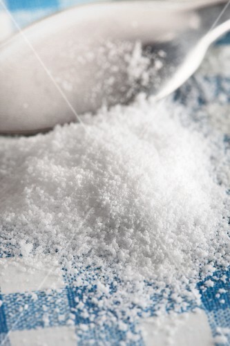 Stevia powder and a teaspoon on a checked surface