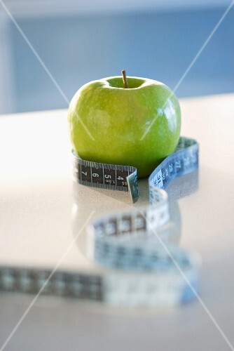 Green apple with tape measure