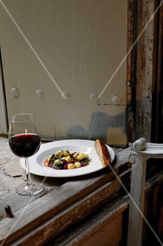 Beef with potatoes, basil and lingon berries and a glass of red wine