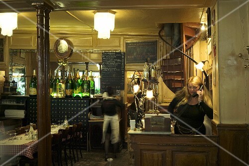 A woman telephoning in the reception of a restaurant