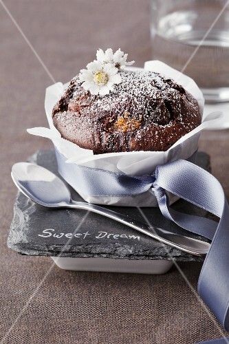 A chocolate muffin decorated with candied daises