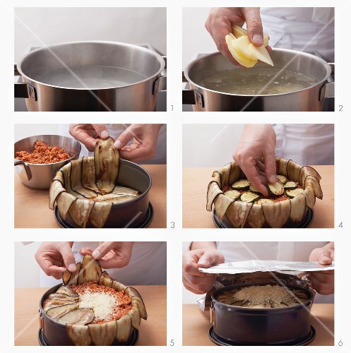 Preparing moussaka in a loose-bottomed tin