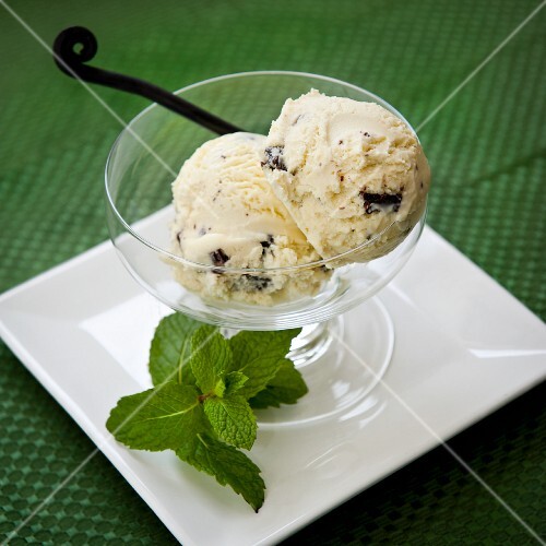 Two Scoops of Mint Chocolate Chip Ice Cream in a Glass Bowl with Mint Garnish