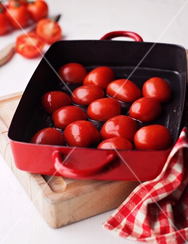 Tomatoes being roasted in a roasting tin