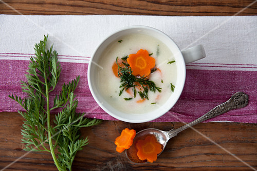 Cream of potato soup garnished with carrots and carrot leaves