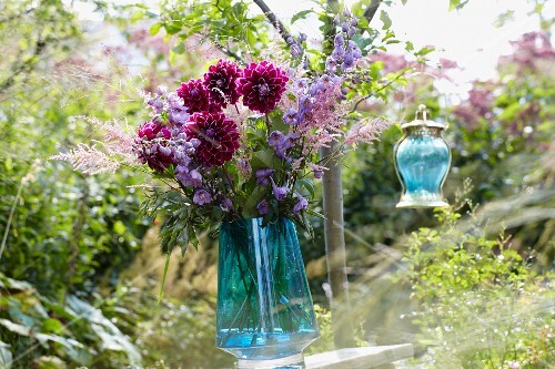 A bunch of summer flowers and a lantern in a garden