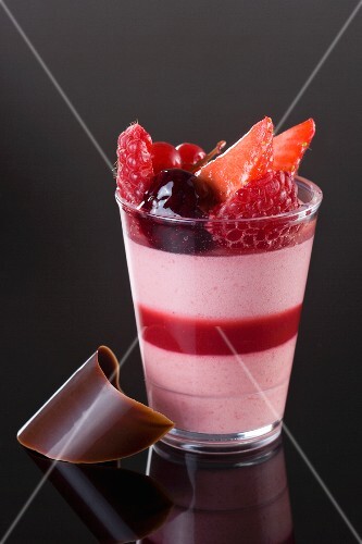 A layered dessert with fruit mousse and berries