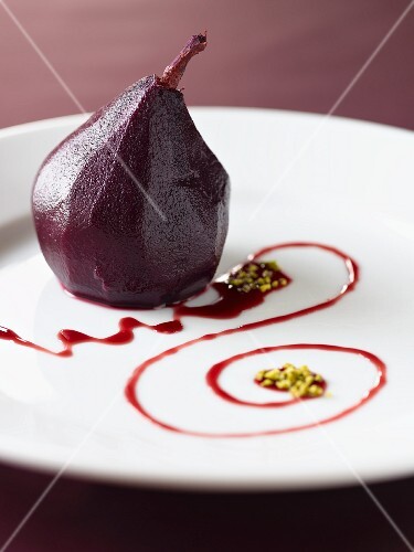 A red wine pear with chopped pistachios