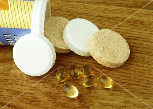 Various vitamin & mineral tablets on wooden background