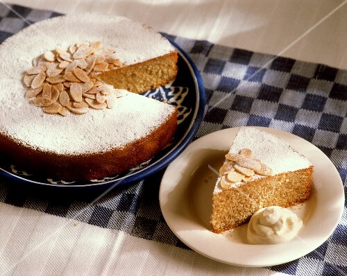Almond cake & a piece of almond cake with cream on plate