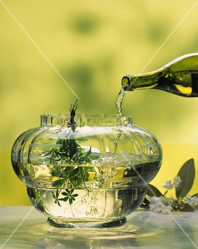 White wine being poured into May wine punch