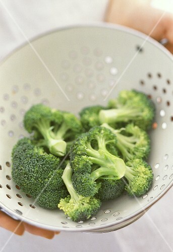 Freshly washed broccoli florets in sieve