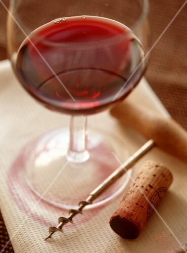 Red wine glass with corkscrew and cork
