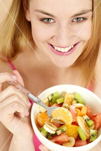 Young woman with a bowl of fruit salad