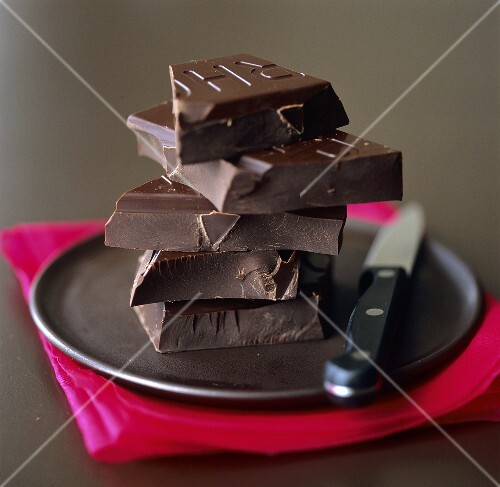 A pile of pieces of Valrhona chocolate on black plate