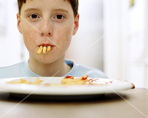 Boy with three chips in his mouth