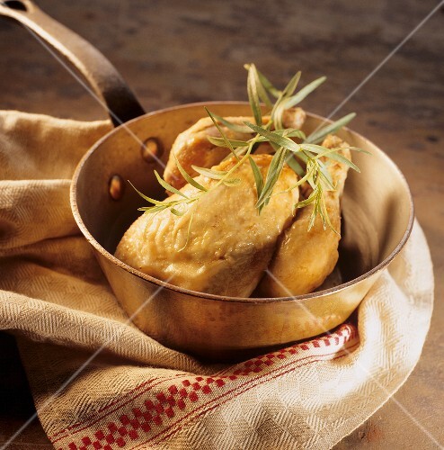 Roast chicken with tarragon in a copper pan