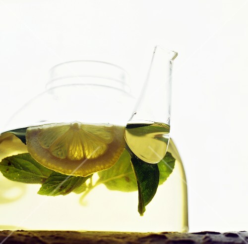 Tea with mint and lemon in glass pot