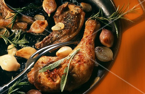 Frying lamb cutlets and chicken leg in frying pan