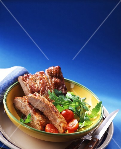 Spare-ribs with rocket and tomatoes